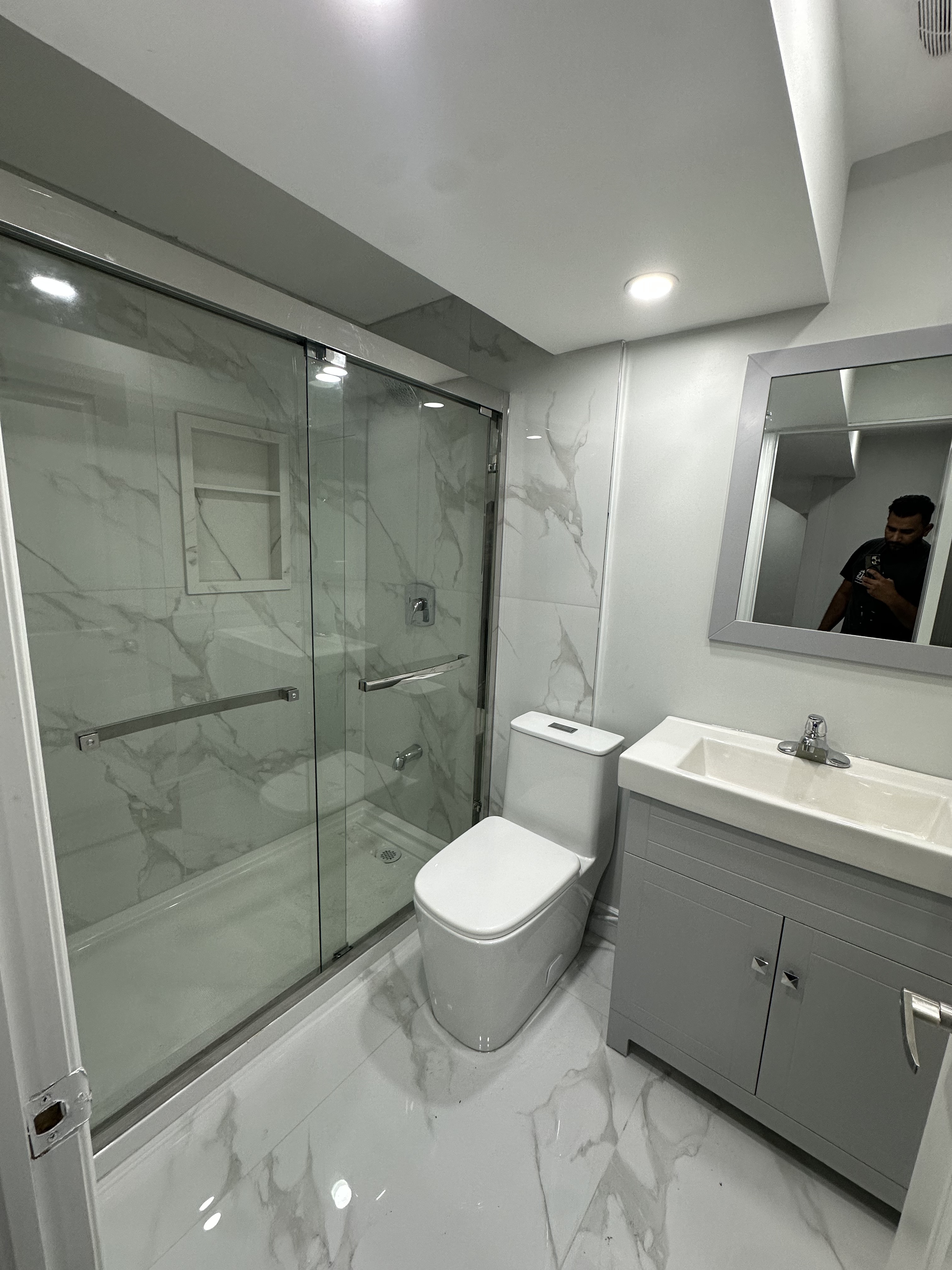 Basement Bathroom — Marble Tile & Glass Enclosure — Basements project by Redstone Construction in Brampton, ON